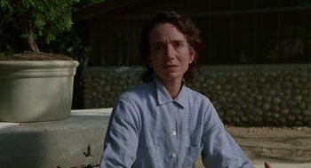 Movie still from “Safe” (1995), directed by Todd Haynes – A woman wearing a blue shirt sitting on a bench; Close Up shot, Low angle