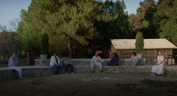 Movie still from “Safe” (1995), directed by Todd Haynes – A group of people sitting on a stone wall; Wide shot, High angle