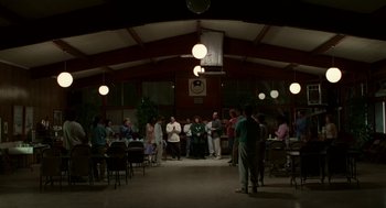 Movie still from “Safe” (1995), directed by Todd Haynes – A group of people standing around a room; Extreme Wide shot, High angle