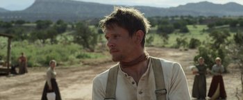 Movie still from “Godless” (2017), directed by Scott Frank – A man in a white shirt is standing in the dirt; Close Up shot, Over the shoulder angle