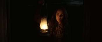 Movie still from “Godless” (2017), directed by Scott Frank – A woman is holding a lantern in the dark; Medium shot, Low angle
