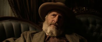 Movie still from “Godless” (2017), directed by Scott Frank – An old man with a beard wearing a hat; Close Up shot, Over the shoulder angle