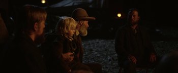 Movie still from “Godless” (2017), directed by Scott Frank – An older man and a young boy sitting on the ground; Medium shot, Over the shoulder angle