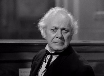 Movie still from “San Francisco” (1936), directed by W.S. Van Dyke – An older man in a black suit and white shirt; Close Up shot, High angle