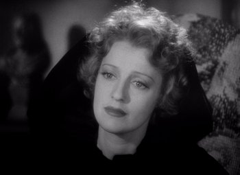 Movie still from “San Francisco” (1936), directed by W.S. Van Dyke – An old photo of a woman in a black shirt; Close Up shot, High angle