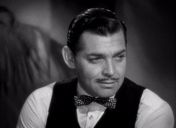 Movie still from “San Francisco” (1936), directed by W.S. Van Dyke – A man in a bow tie and a vest; Close Up shot, Over the shoulder angle