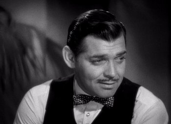 Movie still from “San Francisco” (1936), directed by W.S. Van Dyke – A man that is wearing a bow tie; Close Up shot, Over the shoulder angle