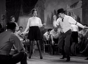 Movie still from “San Francisco” (1936), directed by W.S. Van Dyke – A man and a woman are dancing in front of a group of people; Wide shot, High angle