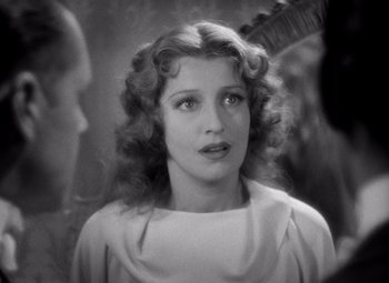 Movie still from “San Francisco” (1936), directed by W.S. Van Dyke – A young woman in a white dress looking at the camera; Close Up shot, Over the shoulder angle