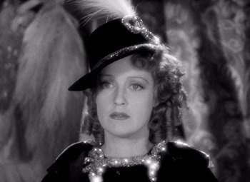 Movie still from “San Francisco” (1936), directed by W.S. Van Dyke – A black and white photo of a woman wearing a hat; Close Up shot, High angle