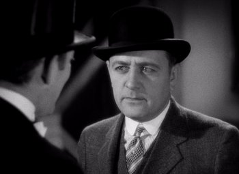 Movie still from “San Francisco” (1936), directed by W.S. Van Dyke – A man wearing a suit and a top hat; Close Up shot, Over the shoulder angle