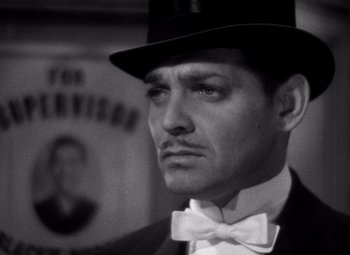 Movie still from “San Francisco” (1936), directed by W.S. Van Dyke – A person wearing a top hat and a bow tie; Close Up shot, Low angle