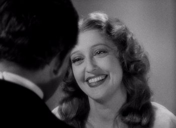 Movie still from “San Francisco” (1936), directed by W.S. Van Dyke – An old photo of a man and a woman smiling for the camera; Close Up shot, Over the shoulder angle
