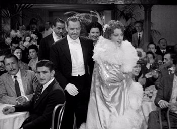 Movie still from “San Francisco” (1936), directed by W.S. Van Dyke – A man and a woman in formal wear standing in front of a crowd; Medium shot, Over the shoulder angle