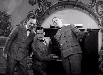 Movie still from “San Francisco” (1936), directed by W.S. Van Dyke – A group of men in suits posing for a picture; Medium shot, Low angle