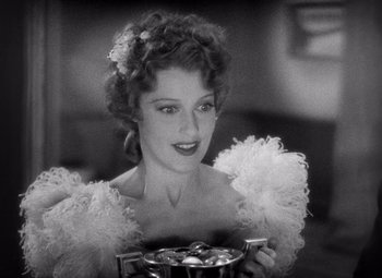 Movie still from “San Francisco” (1936), directed by W.S. Van Dyke – A black and white photo of a woman holding a box; Close Up shot, High angle