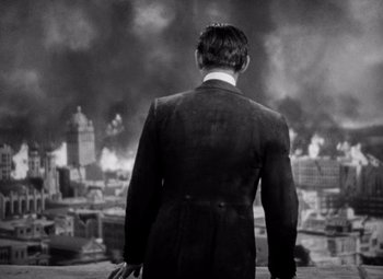 Movie still from “San Francisco” (1936), directed by W.S. Van Dyke – A black and white photo of a man in a suit looking out over a city; Medium shot, Low angle