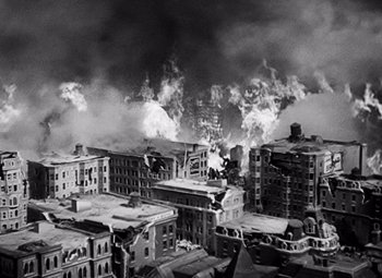 Movie still from “San Francisco” (1936), directed by W.S. Van Dyke – A black - and - white photo of a city with a lot of smoke; Extreme Wide shot, High angle