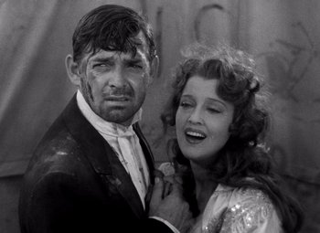 Movie still from “San Francisco” (1936), directed by W.S. Van Dyke – A man and a woman posing for a picture; Medium shot, High angle