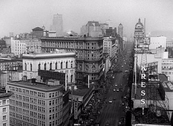 Movie still from “San Francisco” (1936), directed by W.S. Van Dyke – A black - and - white photo of a city street; Extreme Wide shot, High angle
