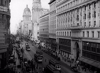 Movie still from “San Francisco” (1936), directed by W.S. Van Dyke – A black and white photo of a busy city street; Extreme Wide shot, High angle