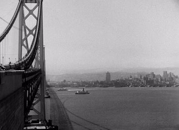 Movie still from “San Francisco” (1936), directed by W.S. Van Dyke – A view of a bridge and a city from a distance; Extreme Wide shot, Low angle