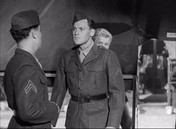 Movie still from “Sands of Iwo Jima” (1949), directed by Allan Dwan – A man in a military uniform talking to another man in uniform; Medium shot, Over the shoulder angle