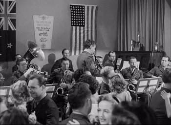 Movie still from “Sands of Iwo Jima” (1949), directed by Allan Dwan – A group of people that are sitting in a room; Wide shot, Low angle