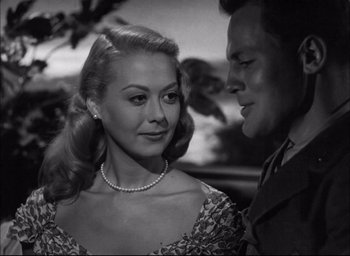 Movie still from “Sands of Iwo Jima” (1949), directed by Allan Dwan – A man and a woman standing next to each other in front of a tree; Close Up shot, Low angle