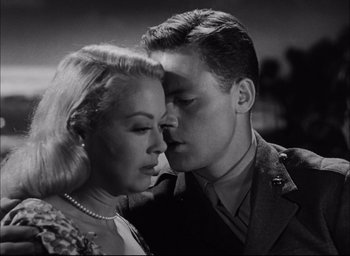 Movie still from “Sands of Iwo Jima” (1949), directed by Allan Dwan – A man and a woman kissing in a black and white photo; Close Up shot, Low angle