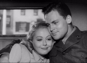Movie still from “Sands of Iwo Jima” (1949), directed by Allan Dwan – A man and a woman sitting next to each other in a car; Close Up shot, Low angle