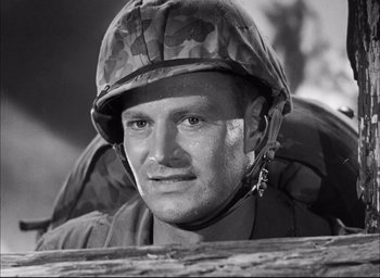 Movie still from “Sands of Iwo Jima” (1949), directed by Allan Dwan – Black and white photograph of a man wearing a helmet; Close Up shot, Low angle