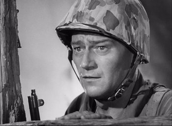 Movie still from “Sands of Iwo Jima” (1949), directed by Allan Dwan – A man wearing a helmet and holding a rifle; Close Up shot, Low angle