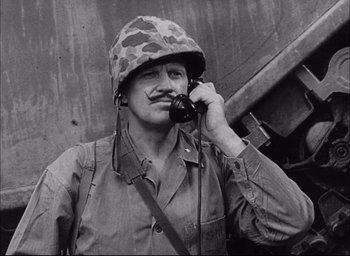Movie still from “Sands of Iwo Jima” (1949), directed by Allan Dwan – A man wearing a helmet talking on a phone; Close Up shot, High angle