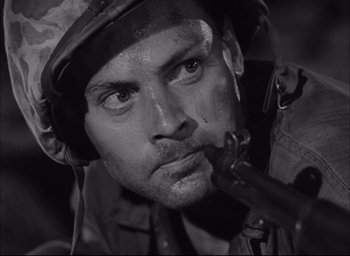 Movie still from “Sands of Iwo Jima” (1949), directed by Allan Dwan – Black and white photograph of a man in a helmet; Close Up shot, Low angle