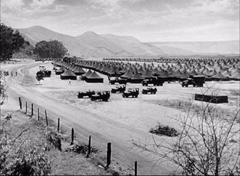 Movie still from “Sands of Iwo Jima” (1949), directed by Allan Dwan – An old black and white photo of a military base; Extreme Wide shot, High angle
