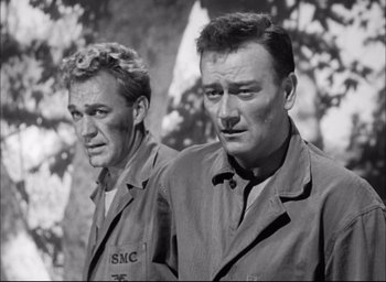 Movie still from “Sands of Iwo Jima” (1949), directed by Allan Dwan – A black - and - white photo of two men standing next to each other; Medium shot, Low angle