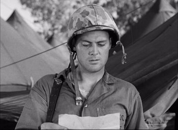 Movie still from “Sands of Iwo Jima” (1949), directed by Allan Dwan – A man wearing a helmet is looking down at a piece of paper; Close Up shot, Low angle