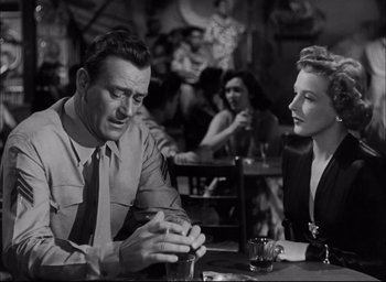 Movie still from “Sands of Iwo Jima” (1949), directed by Allan Dwan – A man and a woman sitting at a table in a restaurant; Medium shot, Over the shoulder angle