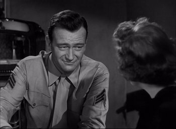 Movie still from “Sands of Iwo Jima” (1949), directed by Allan Dwan – An old photo of a man talking to a woman; Close Up shot, Over the shoulder angle