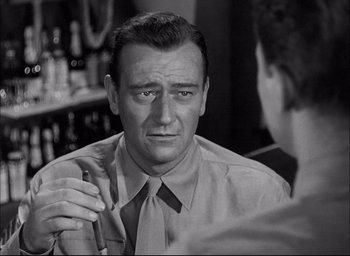 Movie still from “Sands of Iwo Jima” (1949), directed by Allan Dwan – An old photo of an older man in a bar; Close Up shot, Over the shoulder angle