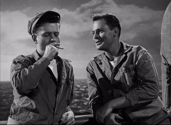Movie still from “Sands of Iwo Jima” (1949), directed by Allan Dwan – A couple of men standing next to each other on top of a boat; Medium shot, Low angle