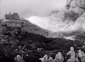 Movie still from “Sands of Iwo Jima” (1949), directed by Allan Dwan – A black and white photo of soldiers in a field; Extreme Wide shot, High angle