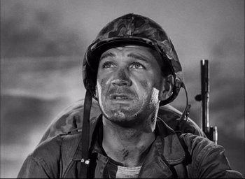 Movie still from “Sands of Iwo Jima” (1949), directed by Allan Dwan – An old black and white photo of a man wearing a helmet; Close Up shot, Low angle