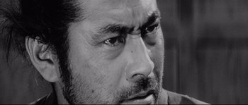 Movie still from “Sanjuro” (1962), directed by Akira Kurosawa – Black and white photograph of a man's face; Extreme Close Up shot, Low angle