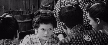 Movie still from “Sanjuro” (1962), directed by Akira Kurosawa – A young woman sitting in front of another young man; Close Up shot, Over the shoulder angle