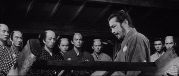 Movie still from “Sanjuro” (1962), directed by Akira Kurosawa – A group of men standing next to each other in a room; Medium shot, Over the shoulder angle