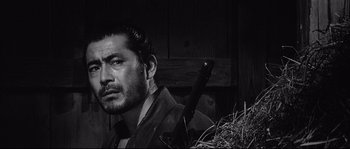 Movie still from “Sanjuro” (1962), directed by Akira Kurosawa – A black and white photo of a man holding a sword; Close Up shot, Over the shoulder angle