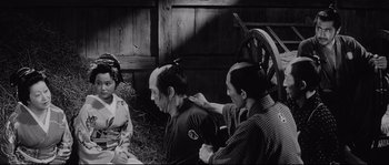 Movie still from “Sanjuro” (1962), directed by Akira Kurosawa – A man and two women are combing each other's hair; Medium shot, Over the shoulder angle