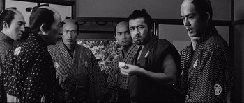 Movie still from “Sanjuro” (1962), directed by Akira Kurosawa – A group of men standing next to each other in a room; Medium shot, Over the shoulder angle